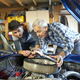 A father and son working on a classic car together.