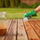 A wood deck with someone applying stain.