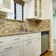 kitchen with white cabinets, tile backsplash, and wood floors