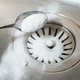 pouring baking soda in a drain