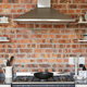 A brick walled kitchen with shelves