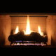 A propane-fueled fireplace burning in a dark room.