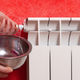 hands draining radiator into bowl