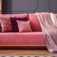 pink couch with pillows and blanket