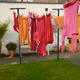 A clothesline in an urban backyard with clothes hanging to dry.