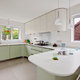 Kitchen with light green cabinets and light laminate countertops.