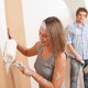 female male couple painting a wall