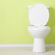 white toilet sitting against a yellow wall