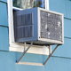 A window air conditioning unit in a blue house.
