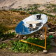 A parabolic solar cooker in full light.