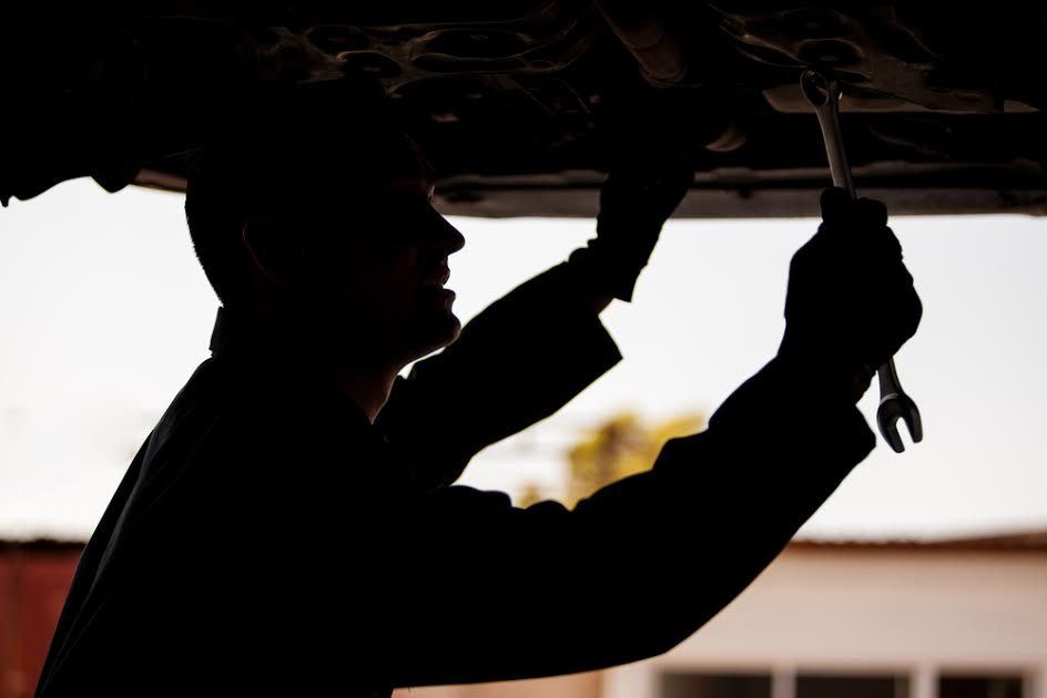 shadow of person working underneath a car