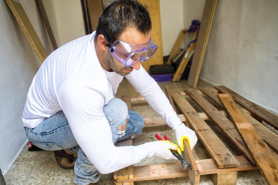 A man removing nails from a pallet. 