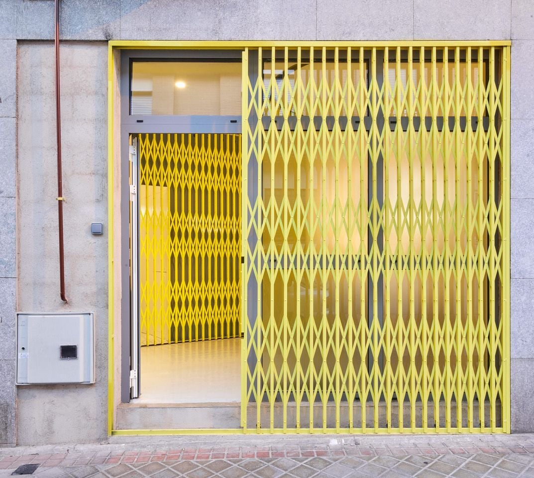 Sliding yellow gate at the entryway of Madrid-based trap star Kaydy Cain's street art-inspired home studio. 