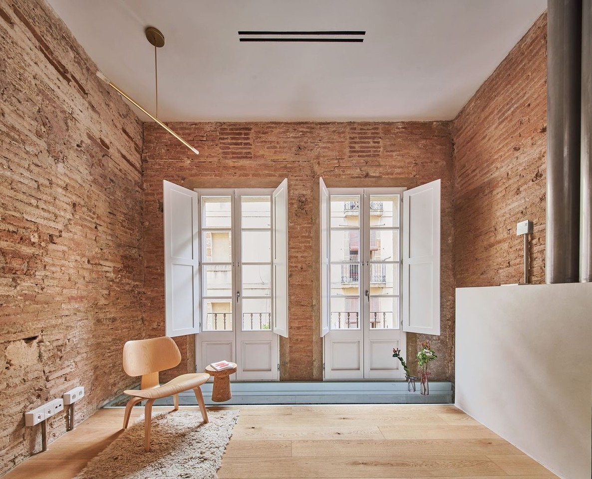 Simple exposed brick living space in the Raúl Sánchez-renovated BSP 20 apartment in Barcelona.