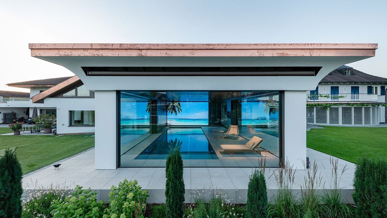 Air-Lux descending windows installed around a large transitional swimming pool space.