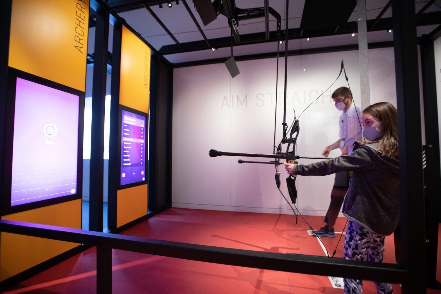 Young girls tries out a virtual archery exhibit inside the new US Olympic and Paralympic Museum.