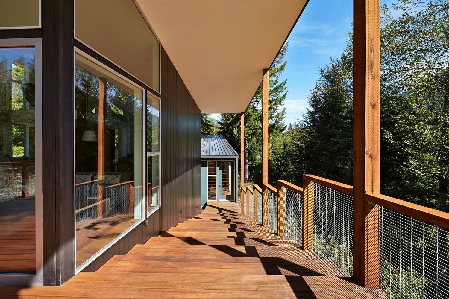 A rustic outer deck encircles the cabin's main volume. 