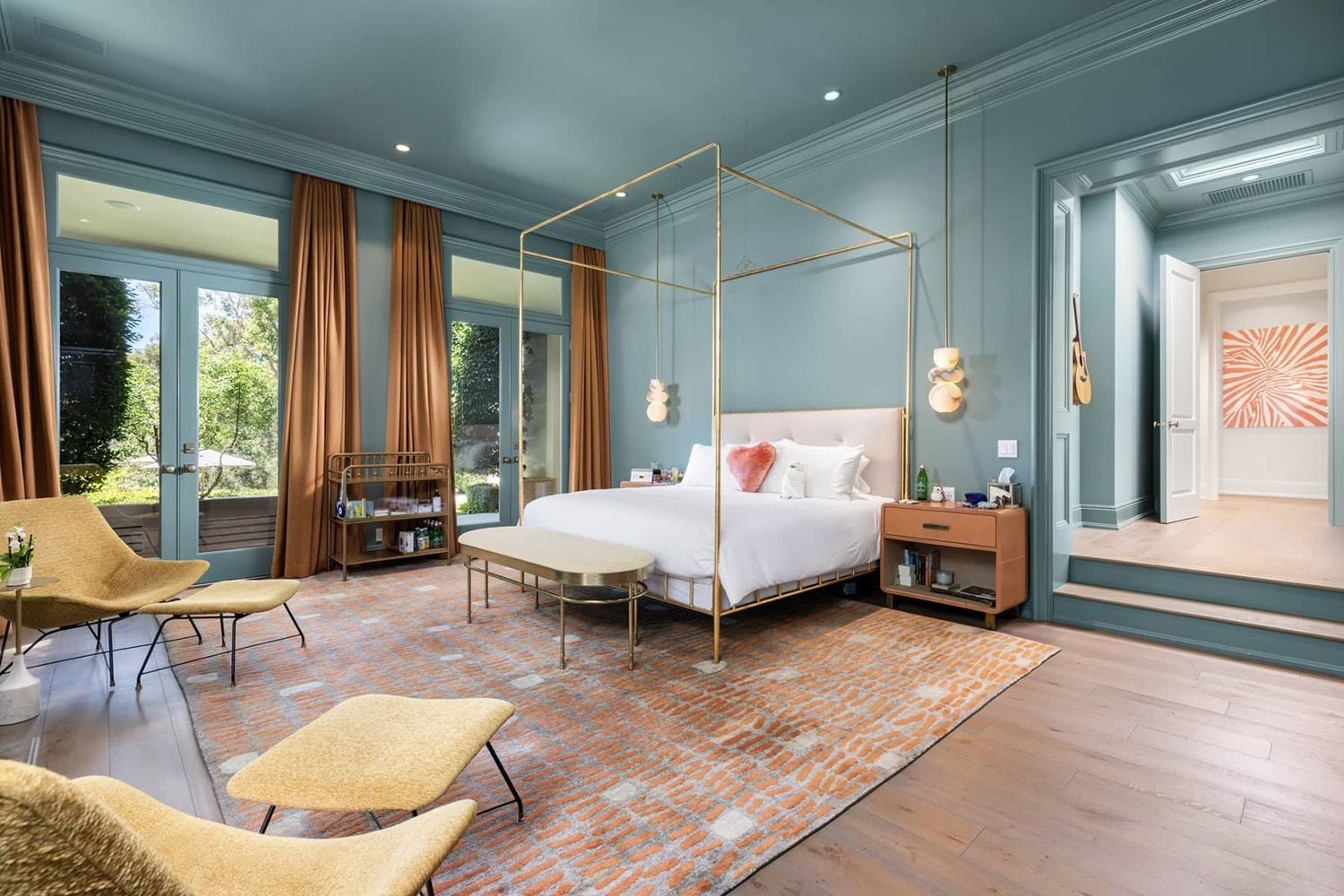 Expansive bedroom in Katy Perry's on-sale Beverly Hills home, painted in a calming blue-gray. 