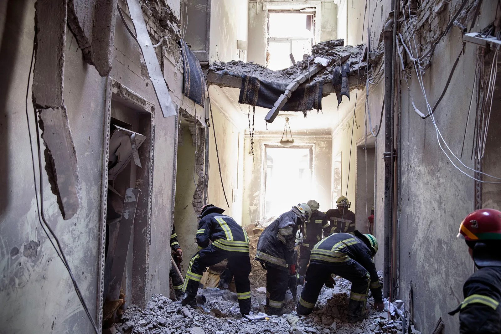 FIrefighters come through the rubble in the destroyed Ukrainian city of Kharkiv.