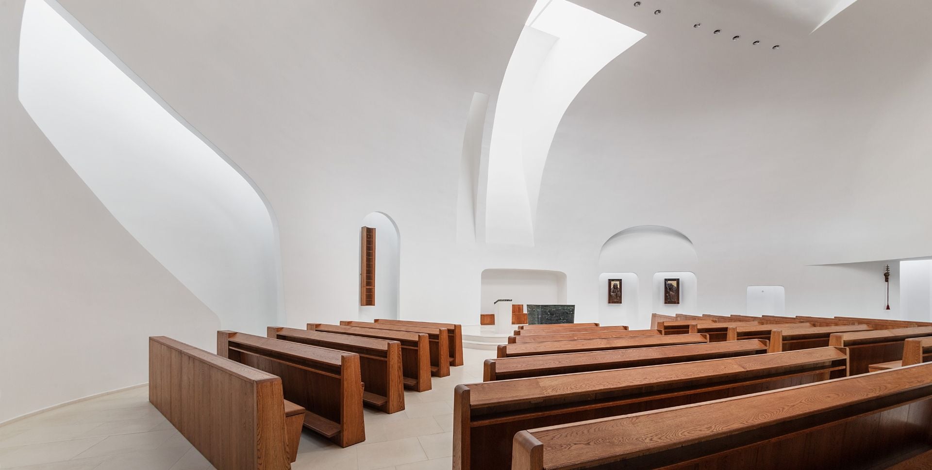 Left-side view of the minimalistic chapel and pews inside the Saint Pope John Paul II Church.