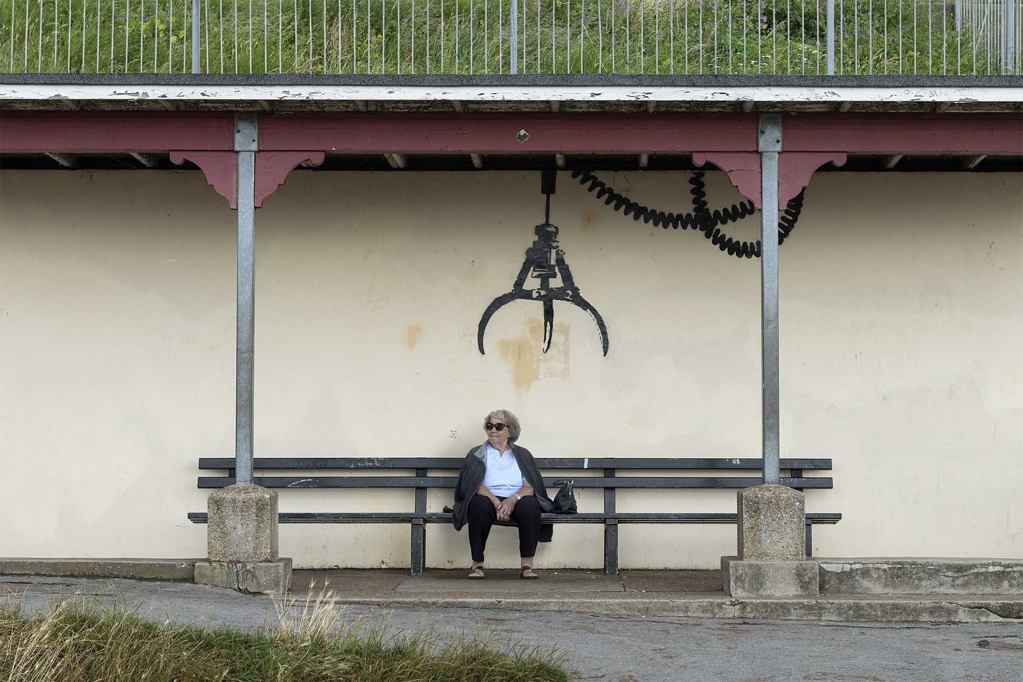 Large arcade-style claw painted over a bus stop as part of Banksy's new 