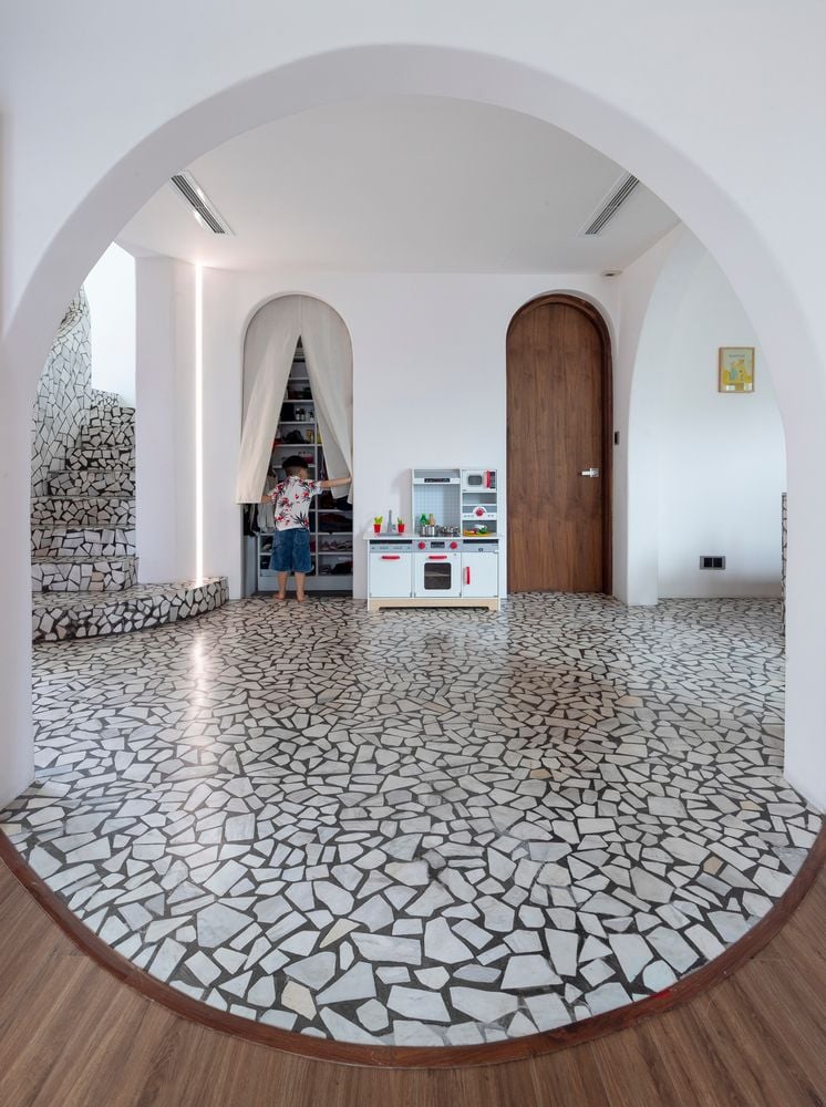 Bold terrazzo floors blend seamlessly with the apartments many archways and white walls. 