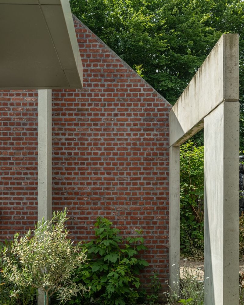 Newer concrete archways rest on one of the Belgian farmhouse's original brick walls.