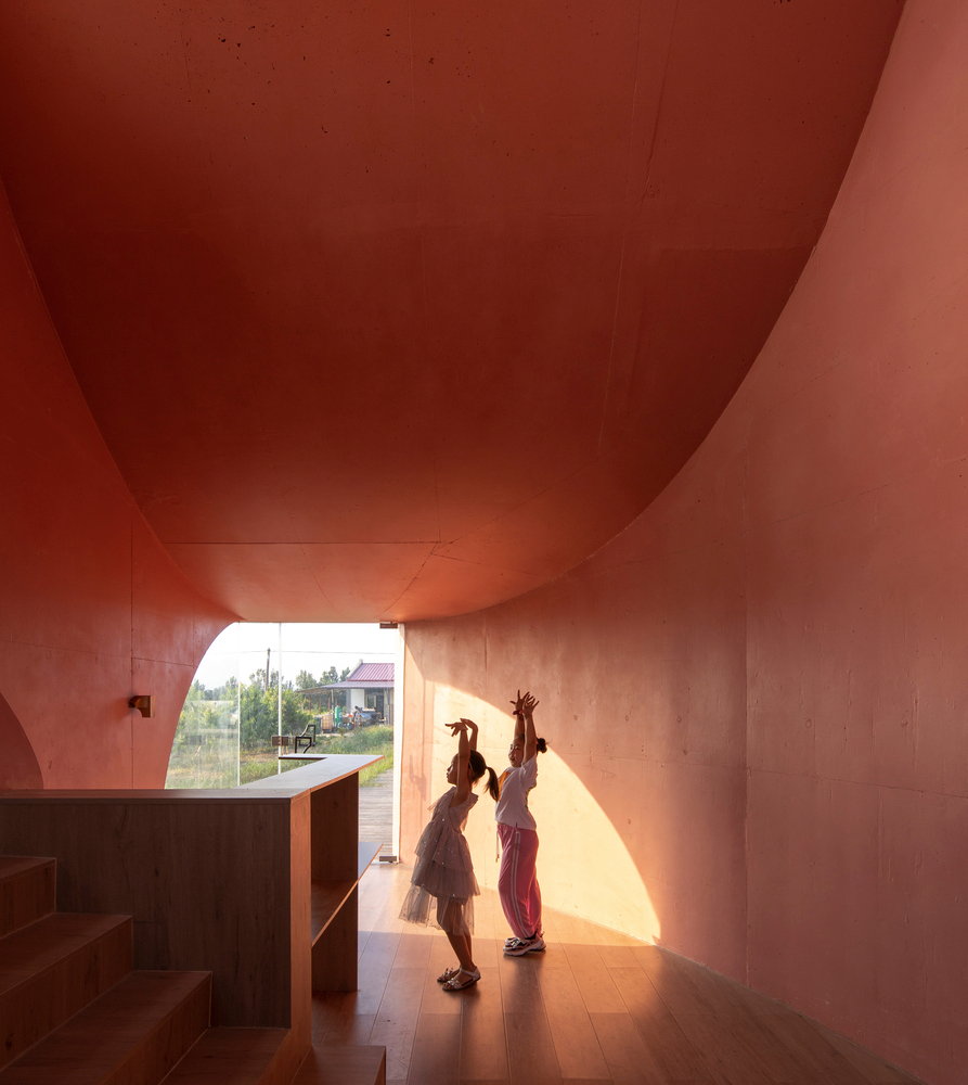 Two young girls rehearse their dance moves inside the contemporary Peach Hut pavilion.