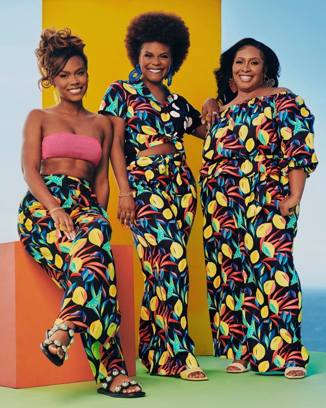 Tabatha Brown poses with two models in a bold patterned dress featured in her upcoming summer collection with Target. 