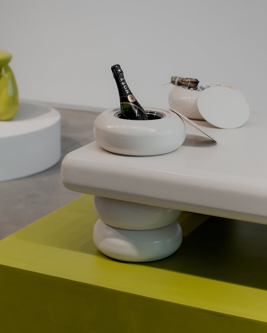 Chilled champagne bottle sits neatly in one of the Taarof table's built-in containers.