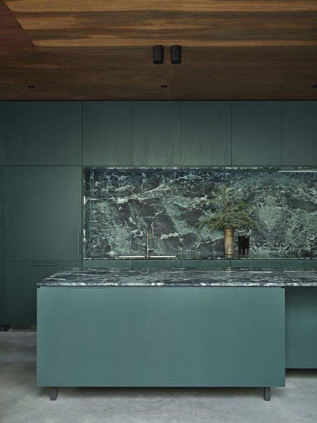 Sage kitchen cabinetry and green marble countertops in the 