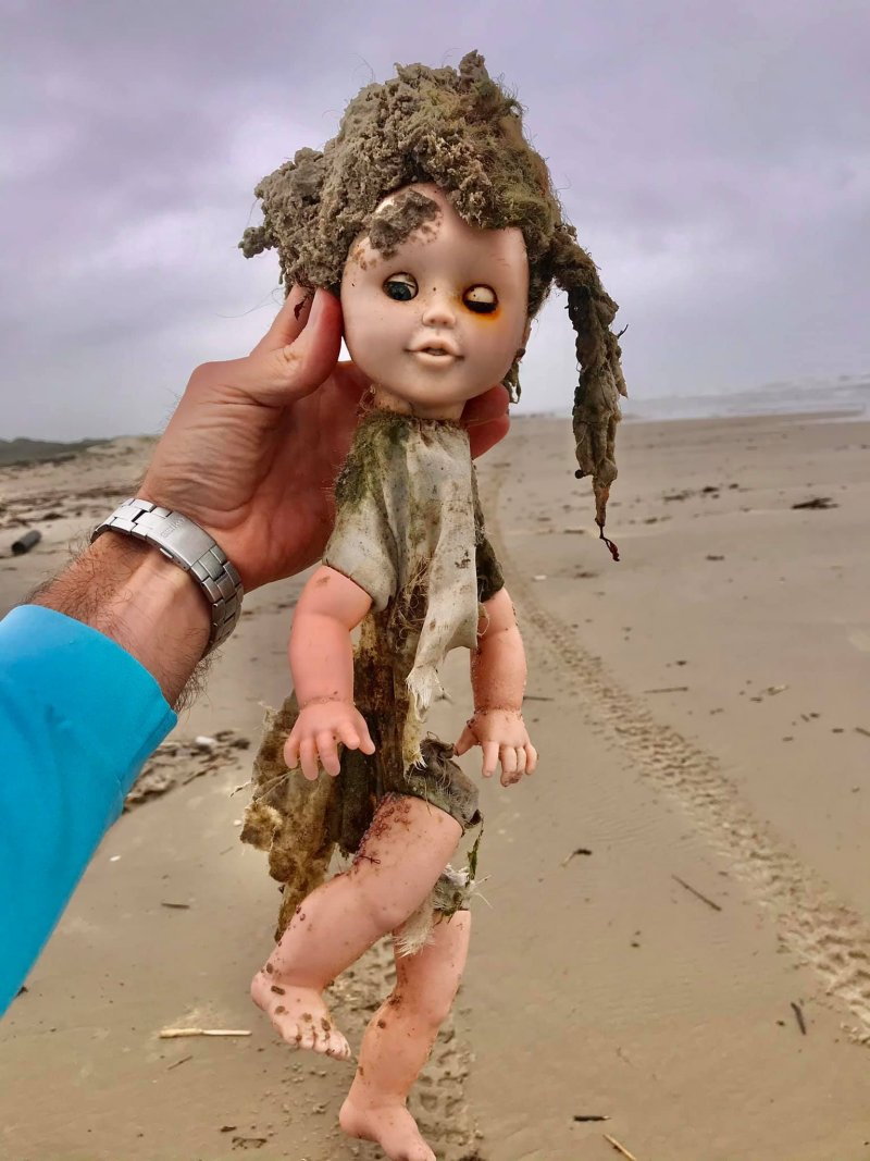 Texas native holds up a creepy doll washed up on the shores of the state's Coastal Bend. 