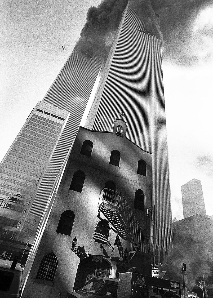 Photo of the original Saint Nicholas Greek Orthodox Church on September 11th, with the Twin Towers on fire in the background. 