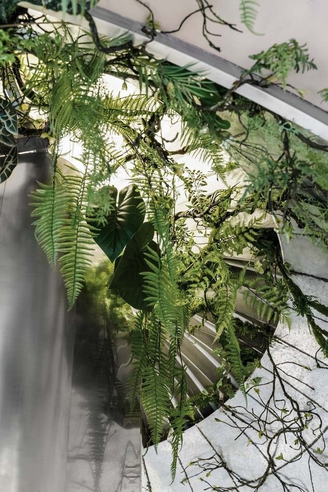 Leafy foliage peeks through the cracks in the metallic walls of Shanghai's Metal Hands Coffee Shop