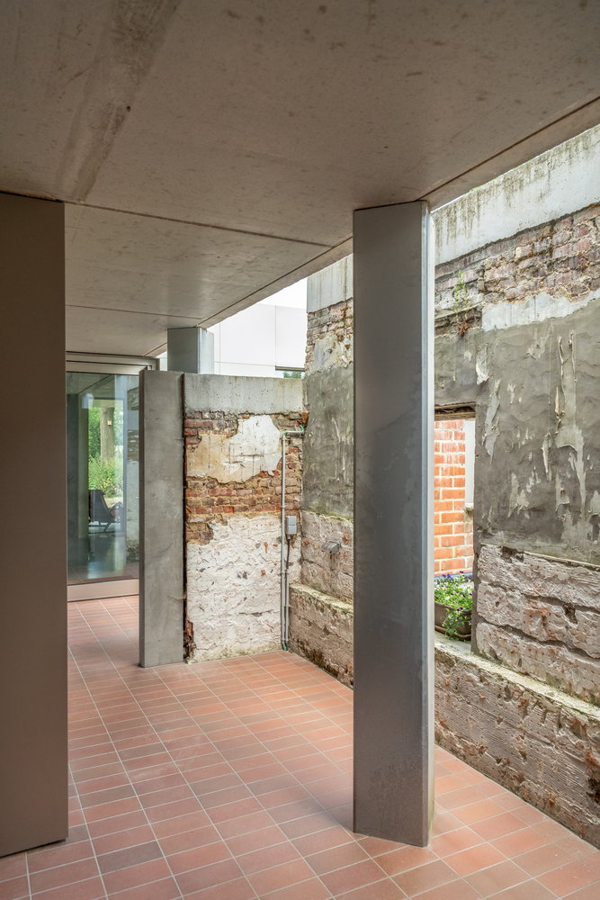 Objekt Architecten blended the Belgian farmhouse's original walls in with newer brick and concrete surfaces.