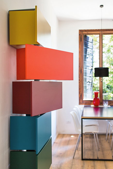 Tower of colorful Giralot storage modules in a contemporary living space, with two in the middle swiveling out.