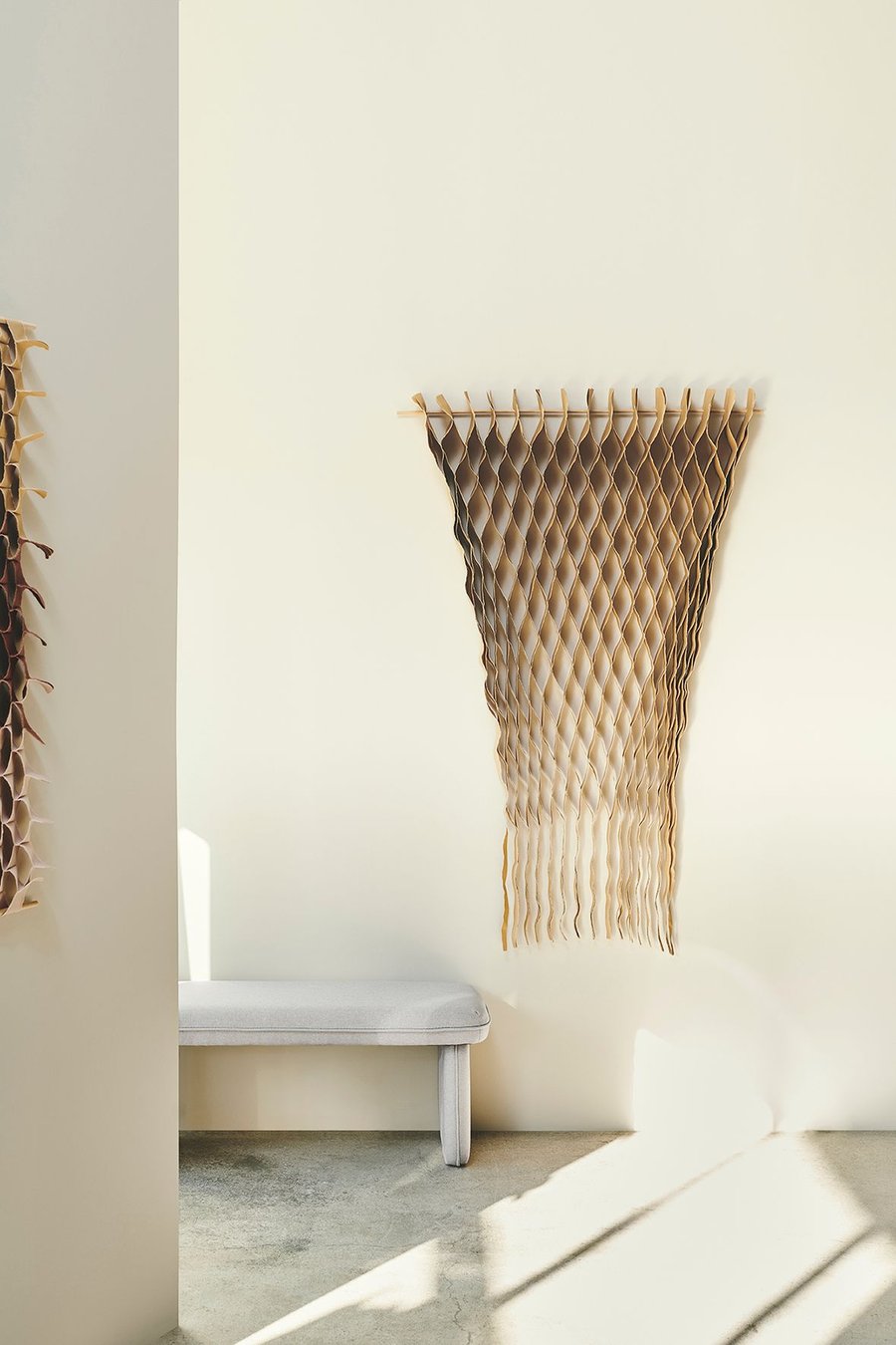 Honeycomb-like hanging textiles from the FLOW collection bring splashes of color and elegance to a modern living space.