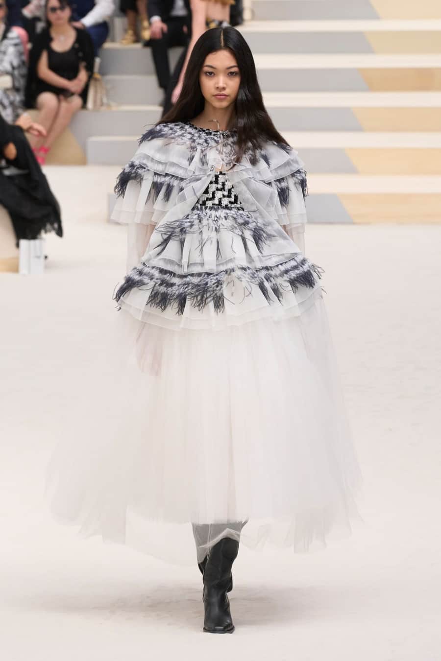Chanel model sports a black and white dress for Paris Fashion Week 2022.