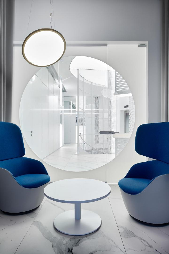 A more private meeting room inside the VIP lounge, complete with wide blue seating and lots of circular decor pieces.