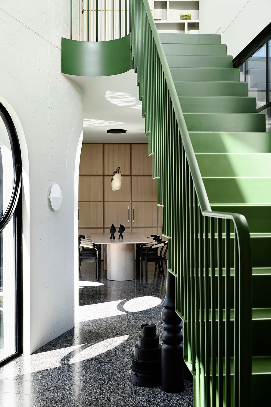 A large green stairway sits at the center of the Caroline House's modern addition.