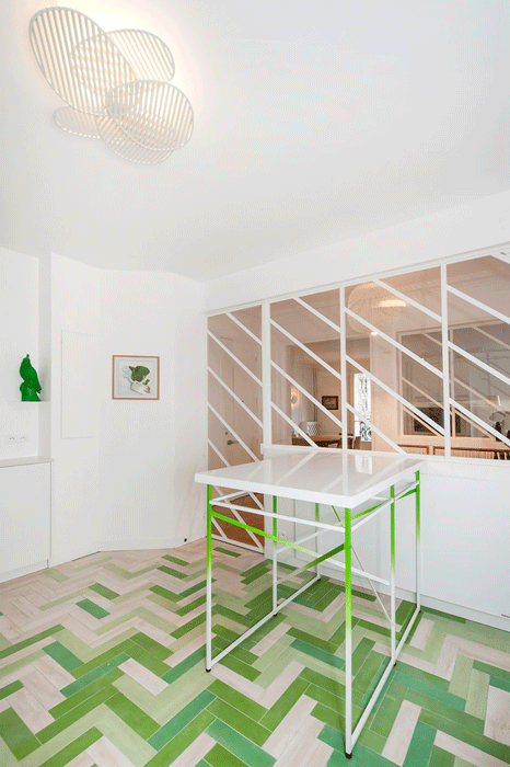 The kitchen of a Paris pied-à-terre renovated by Atelier Pierre Louis Gerlier, complete with the designer's signature diagonal windows. 