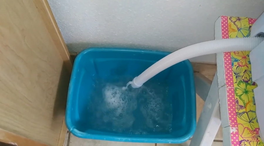 Rinse water from Amazon's Super Deal Portable Washer-Dryer drains into a nearby tub. 