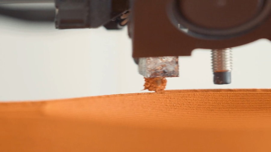 Close-up view of an Ohmie Orange Peel Lamp being 3D printed. 