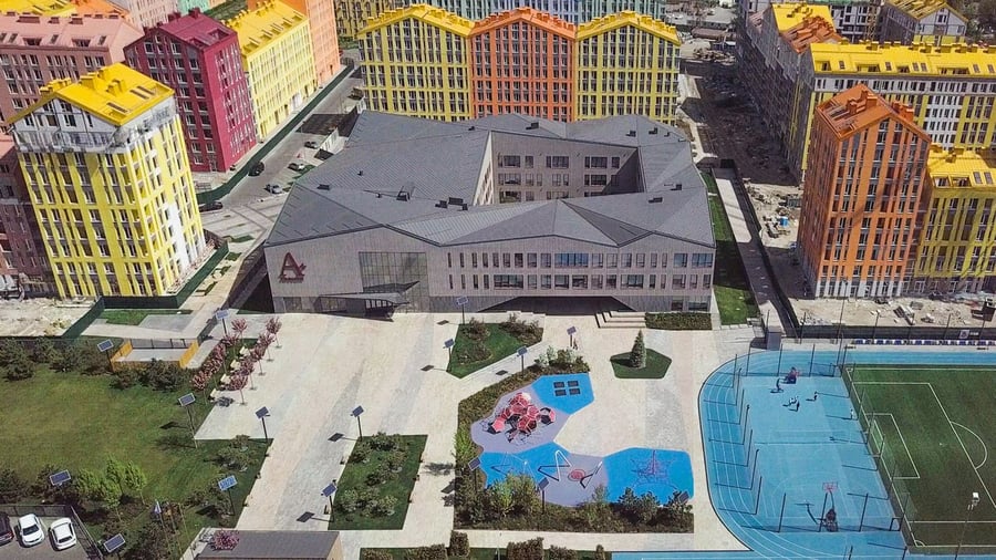 Large colorful playground and soccer field space at the center of Kyiv's new Comfort Town Housing Development. 