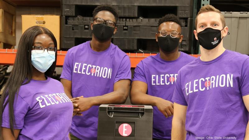 The Electrion team (comprised of students from Ohio State) stands next to their wireless battery pack alternative to gas generators at tailgating events.