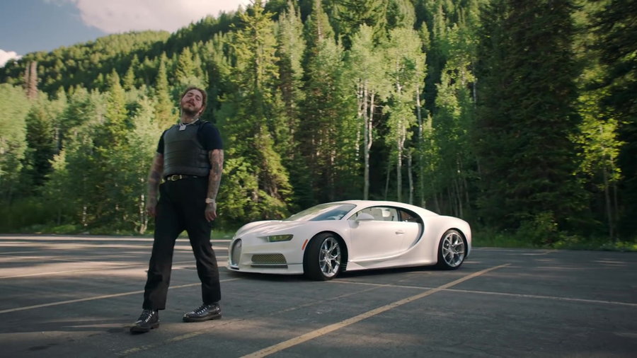 Musician Post Malone stands in front of his custom all-white 2019 Bugatti Chiron. 