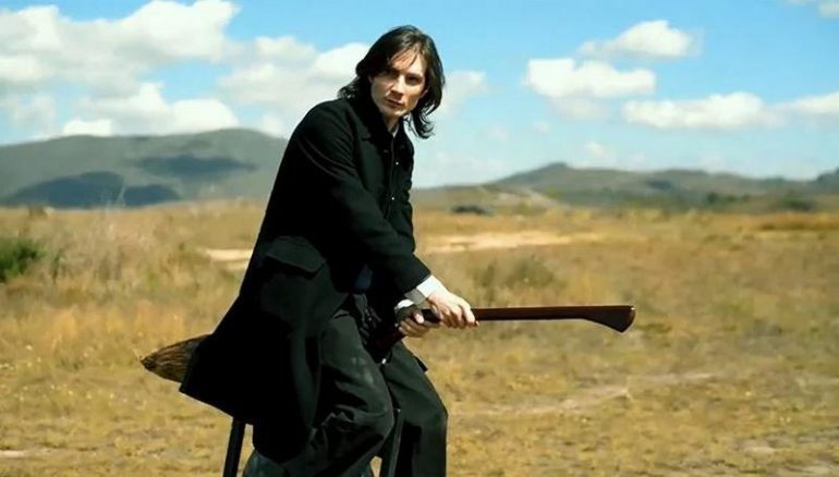Young wizard smolders for the camera as he rides he sleek Nuvem broom through a dry field. 