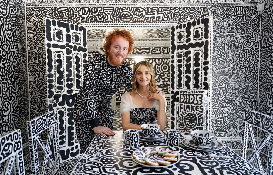 Sam and Alena Cox (aka Mr. and Mrs. Doodle) sit at the doodle-covered dining table in their doodle-covered mansion in Kent, England. 