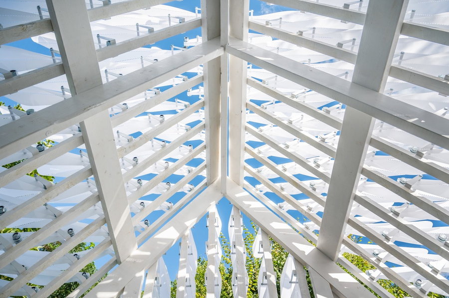 View upward at the Shiver House's kinetic white shingles, all of which move independently from one another to give the whole structure the appearance of movement. 