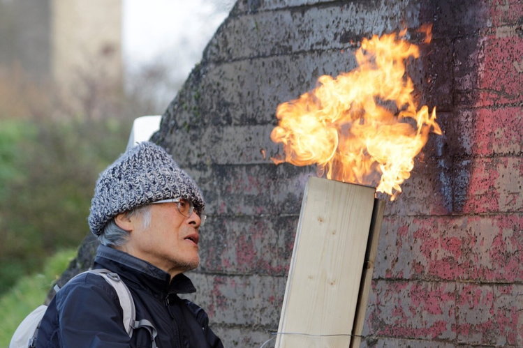 Craftsman uses a torch to give a Japanese Tea House by Terunobu Fujimori a classic shou sugi ban exterior.